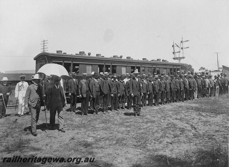 P00520
AA class carriage, men in civilian clothes lined up in ranks in front of the carriage. 
