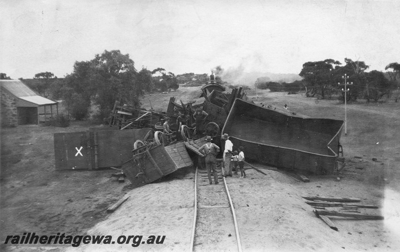 P01073
1 of 3 views of the derailment of No. 11 Mixed, at the 51 mile point near Indarra, NR line, on the 2nd March 1932, showing derailed wagons piled up across the track. Photo taken from the top of the JA class water tank still attached to the loco of the derailed train and looking towards Geraldton. Loco showing in the distance is that of the special train which was following No.11, the derailed train.
