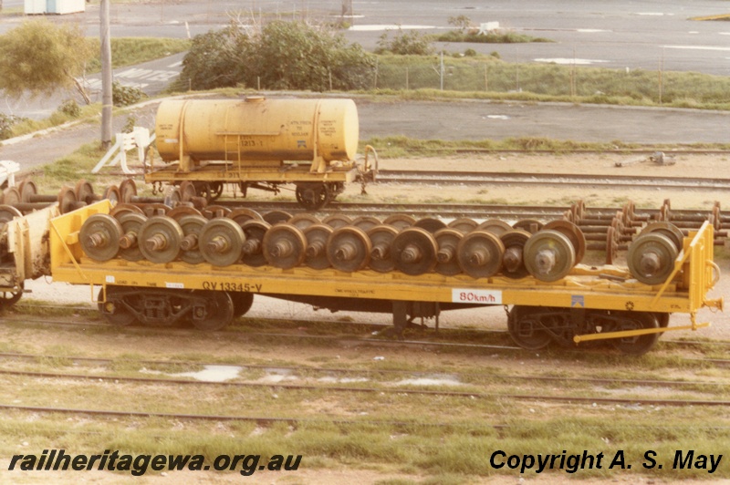 P01246
QV class 13345 wheel wagon loaded with wheel sets, side view, J class 1213 4-wheeled tanker, side view, yellow livery, North Fremantle, ER line.
