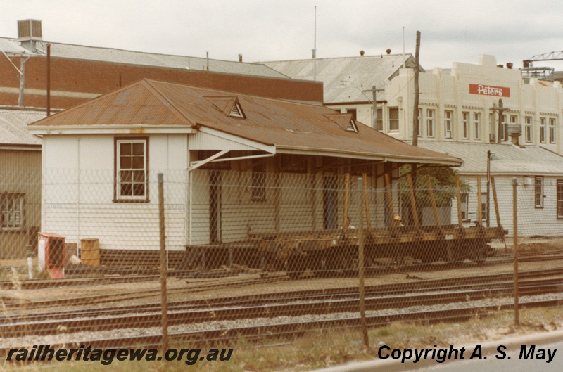 P01275
QBE class bogie bolster wagon, in front of a building at the west end of the carriage sheds, West Perth.
