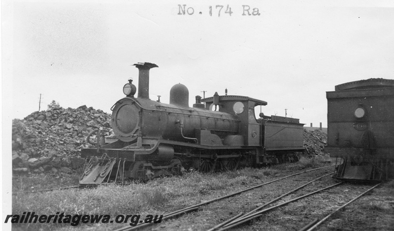 P01633
R class 174 in storage, front and side view. End of the bunker on N class 198 also in the view, c1926
