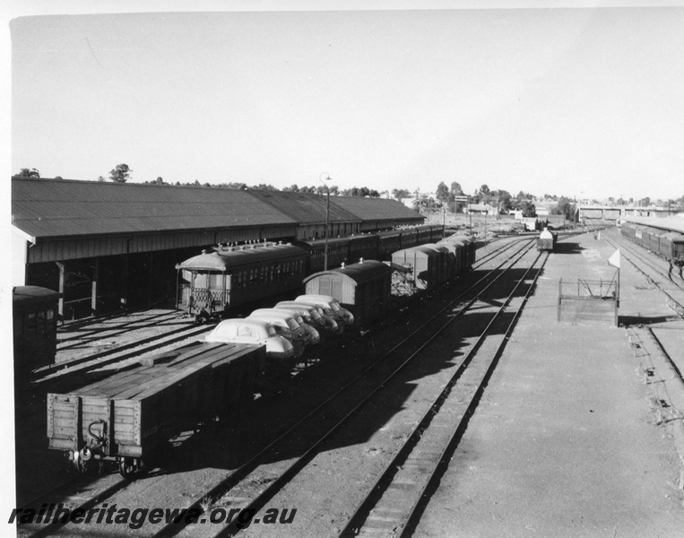 P01704
Kalgoorlie station yard, looking east, lever frame, passenger carriages, goods wagons, sheds.
