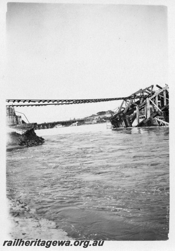 P01802
Collapsed bridge, North Fremantle, due to the 1926 flood, shows rails suspended and the collapsed trusses.
