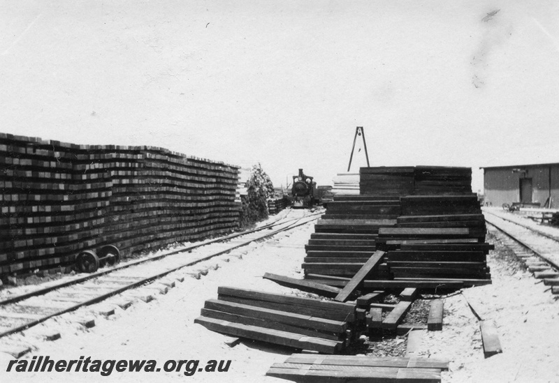 P02082
3 of 44 views of the construction of the railway at Esperance, CE line taken by Cedric Stewart, the resident WAGR engineer, stockpiles of sleepers, G class loco in the background
