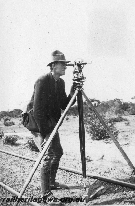 P02086
7 of 44 views of the construction of the railway at Esperance, CE line taken by Cedric Stewart, the resident WAGR engineer, surveyor using a theodolite, surveying the track.
