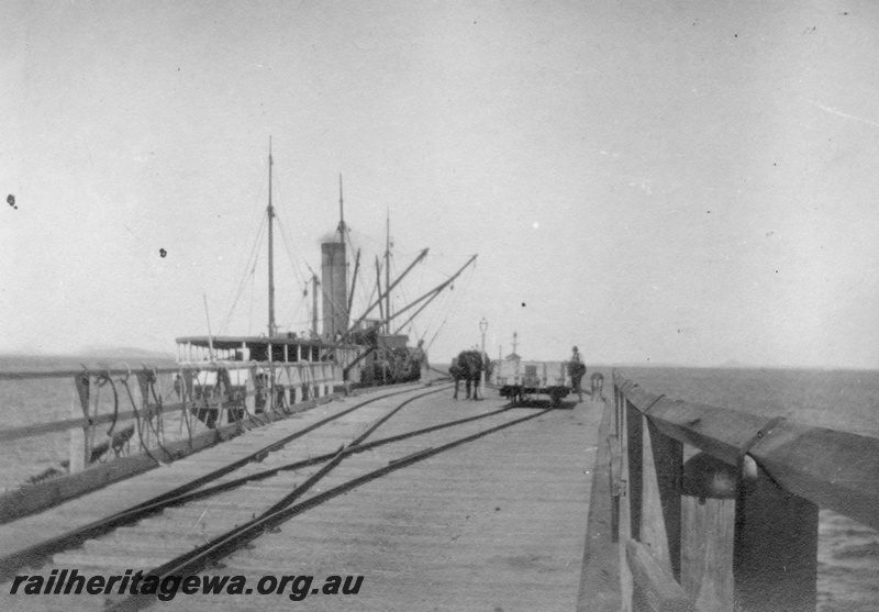 P02146
36 of 44 views of the construction of the railway at Esperance, CE line taken by Cedric Stewart, the resident WAGR engineer, Esperance jetty with ship tied up and horse and wagons on jetty.
