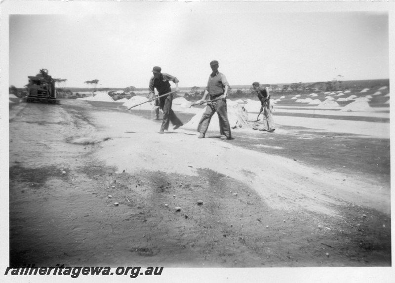 P02166
1 of 5 images of the construction of the dam at Duggan, WLG line showing the laying of bitumen on the catchment area and the covering of the area with sand
