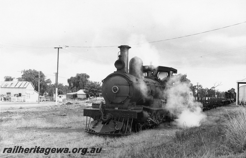 P02366
Millars loco No.71, Yarloop, SWR line, hauling empty bogie flat wagons, front and side view, goods shed in the background.
