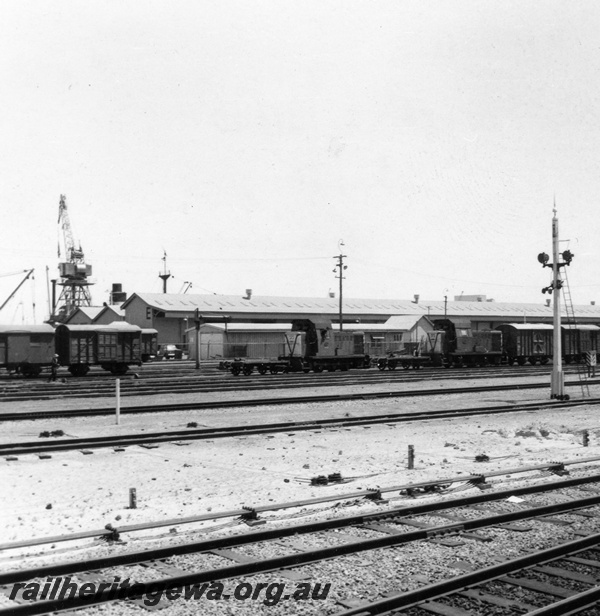 P03162
B class 1606 and B class 1607 diesel hydraulic shunting locomotive, signals, signal rodding, wharf crane, E shed wharf shed, tracks, brakevans, covered vans, Fremantle, ER line.
