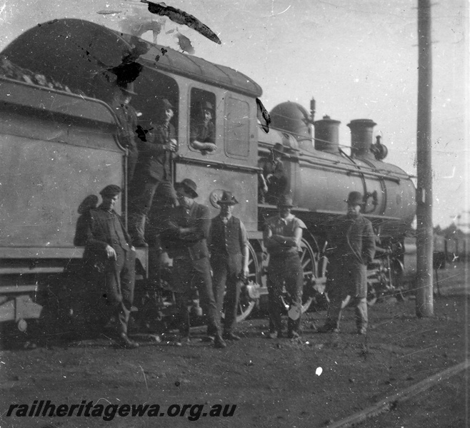 P03656
E class loco with workers in view, in cab, G. Brown, G. Clayton, on the running board, J. Plumb, in front of loco left to right, F. Shenfield, J. Roberts, R. Tanner, G. Meyers, M. Cook, location Unknown, view of side of the loco looking towards the front, Katanning, GSR line.
