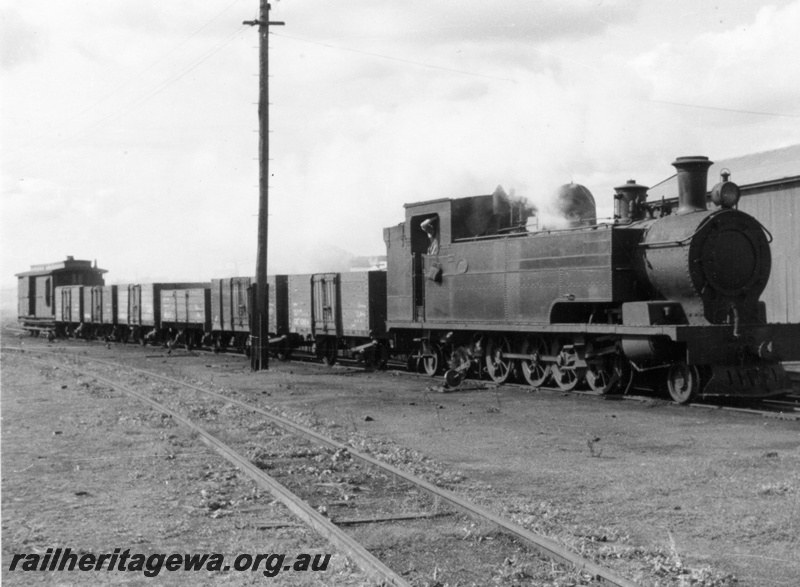 P03699
K class steam loco, on goods train, departing Fremantle, FA line, c1955, first revenue earning train to Coogee South 
