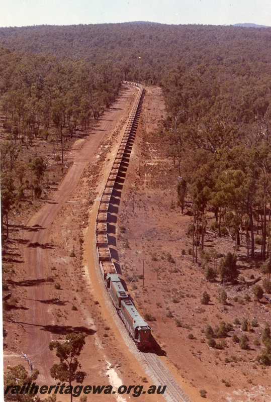 P03780
Double headed D class diesel locomotives in green livery, loaded bauxite train, aerial view along the train. 
