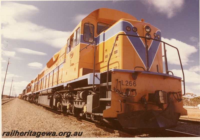P03906
2 of 4, L class 266 diesel locomotive leading a triple headed freight train, running short hood first, side and end view, Westrail orange livery, West Kalgoorlie.

