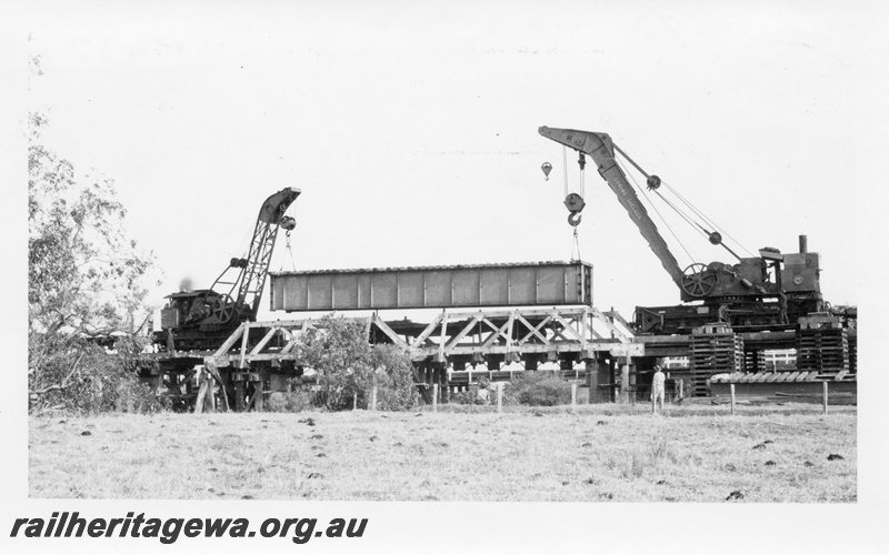 P04326
Steam breakdown cranes Cravens No.25 and Cowans Sheldon No. 31 lowering a steel girder bridge into place replacing the truss bridge at Roelands, SWR line, side view
