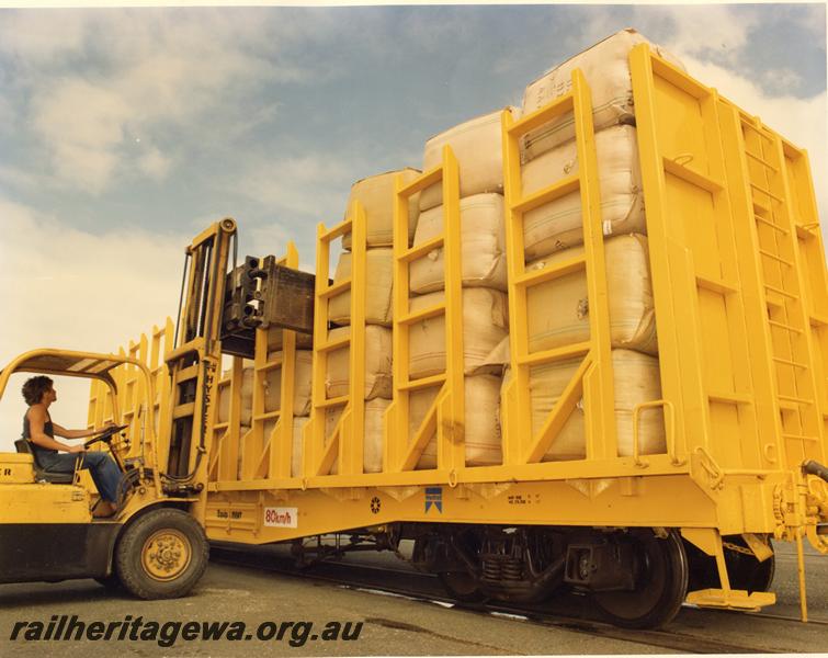 P07441
QUW class wool carrying flat wagon, being loaded by a forklift with wool bales, part side and end view
