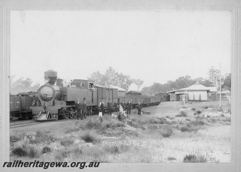 P10198
K class 102 hauling a loaded coal train, station building, Collie, BN line, group of men next to the loco includes the Acting Station Master, Mr F.S. Barnett on the far right 
