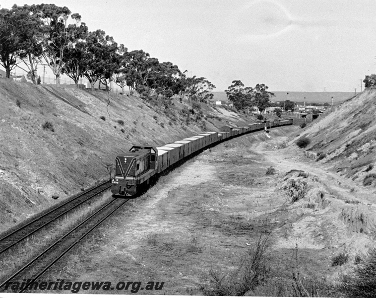 P10329
A class 1506 in green livery hauling wheat train mainly of uncovered open wagons, up the West Leederville Bank towards Fremantle, overall view of the area.
