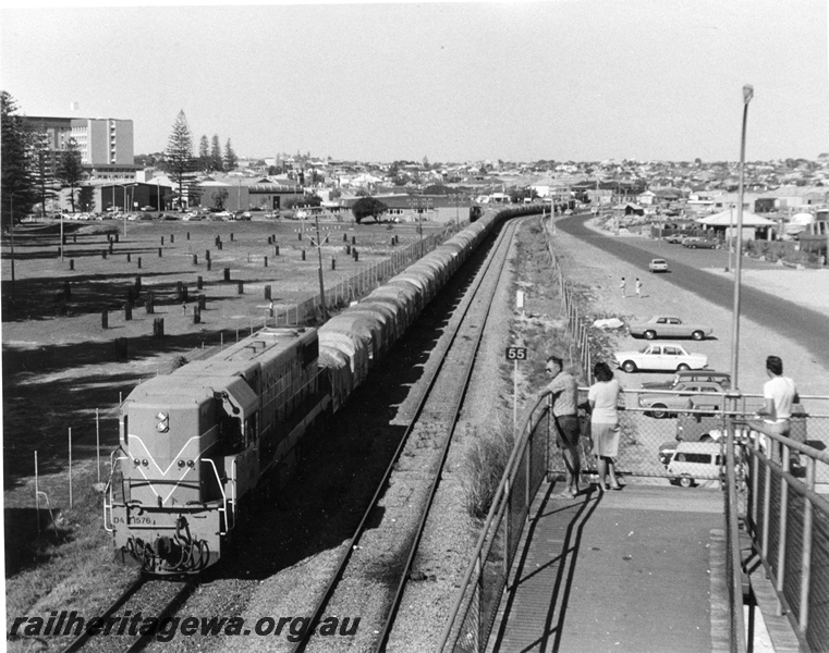 P10347
DA class 1576 Westrail Orange short end leading, hauling wagons covered with tarpaulins. Photographed from footbridge Esplanade Fremantle heading towards Perth. Separate SG track visible. 
