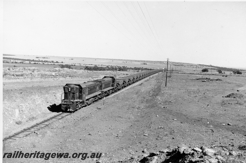 P10354
A class 1513 and 1514. Green with Red and Yellow Stripes. Double heading empty Koolanooka Iron Ore in open country enroute to loading point.
