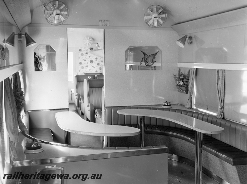 P10397
AYS class buffet car showing curved dining tables, saloon fans and portion of saloon seating. Note the wall mounted overhead lights and wall mounted mirrors.
