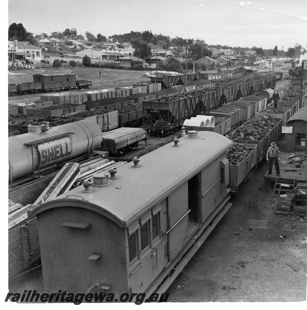 P10932
An overhead view, from the footbridge at Collie, of an unidentified ZB class brakevan at the rear of a coal train. Varied loaded and empty wagons surround the train. Either a guard or a shunter is noted walking on the top of the coal loaded wagons.
