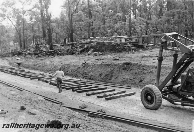 P12024
2 of 12 images of the construction of the Kwinana to Jarrahdale railway. (ref: The Railway Institute Magazine, July 1963).shows the method of lifting the rails onto the sleepers by means of a mobile crane.

