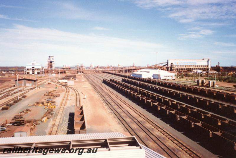 P12547
View from Port Hedland Nelson Point Yard Control Tower looking west, buildings are, wheel lathe, TCB2, car dumpers in the middle distance, loco overhaul workshop, TCB1 and the loco wash plant, empty and loaded rakes of original style ore cars
