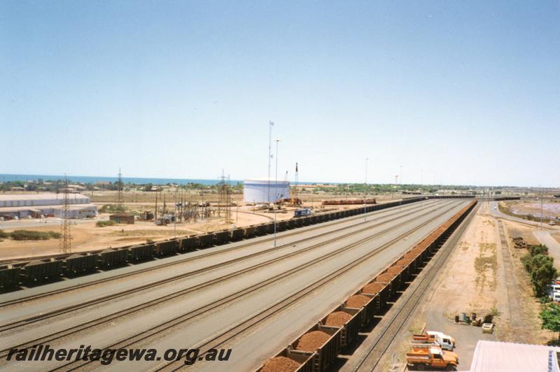 P12549
View from Port Hedland Nelson Point Yard Control Tower looking east, original power station, million gallon diesel fuel tank, former Goldsworthy A class locos being transferred to road floats, loaded ore car rakes
