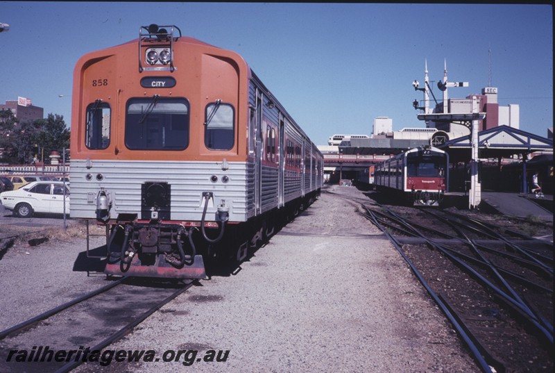 P12862
ADC class 859 railcar trailer on ADL/ADC set with orange front with red stripe on the sides, ADL/ADC set on adjacent track, signal, Perth Station, front and side view.
