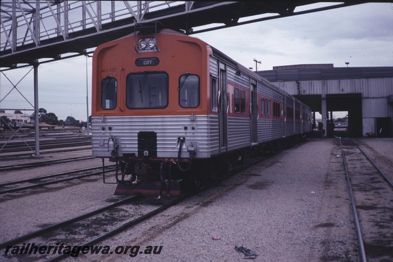 P12863
ADC class 859 railcar trailer on ADL/ADC set with orange front with red stripe on the sides, Claisebrook Railcar Depot, front and side view.
