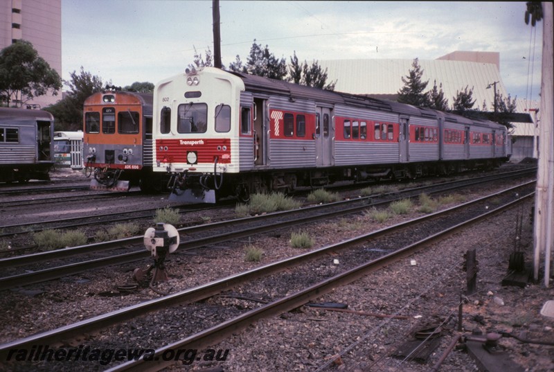 P12865
ADL class 802 on ADL/ADC railcar set with white and red front with red stripe on sides, front of ADK class 686, Perth Yard, front and side view.
