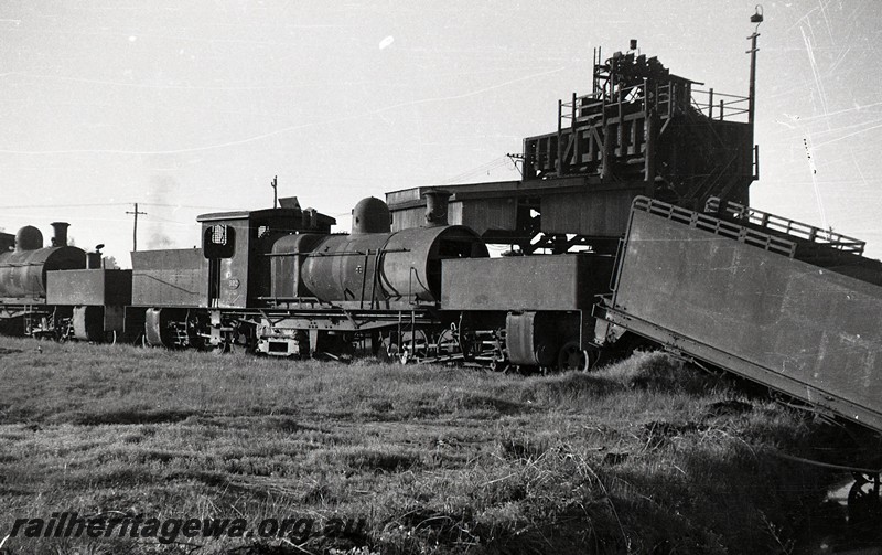 P13048
M class 392 Garratt loco with an extended bunker, front tank of a MS class Garratt loco, tender from a Q class 4-6-0 loco, loco depot, Midland Junction, side and front view.c1950s

