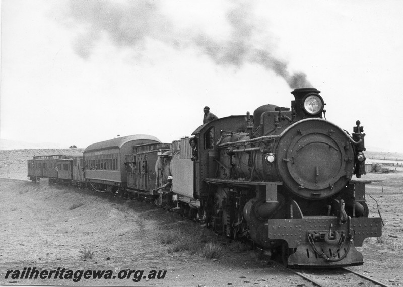 P13099
1 of 3 views of PMR class 720, partially repainted, in the ownership of Steamtown Peterborough in South Australia, in steam hauling a train comprised of brakevans and carriages. (possibly on its trial run) This loco was purchased by Steamtown in 1978 and arrived in Peterborough on 17th, January 1979. (ref: WAGR Steam Locomotives in Preservation, page 27), side and front view
