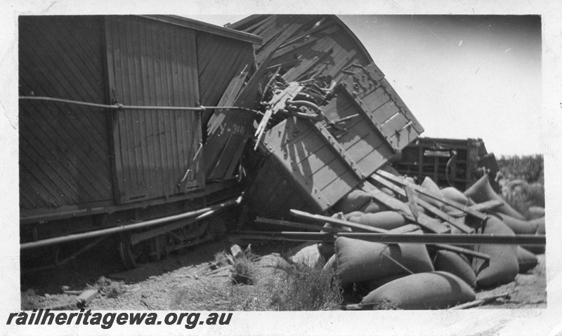 P13501
1 of 5 views of a derailment, date and location Unknown, view shows derailed and smashed wagons with bagged wheat strewn on the ground.
