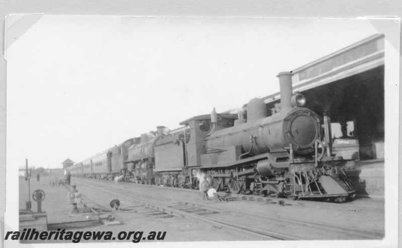 P14180
R class with an oil headlight and a bar cowcatcher coupled to a P class hauling a passenger train, Kalgoorlie station, ERG line, view along the train.
