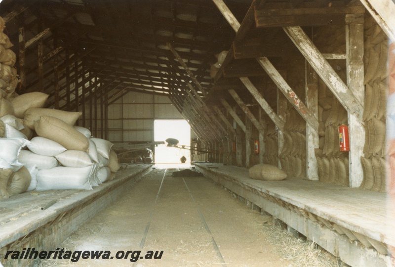 P14710
Inside Burrage & Warren's shed showing rail line and loading dock and bags of grain or chaff, York, GSR.
