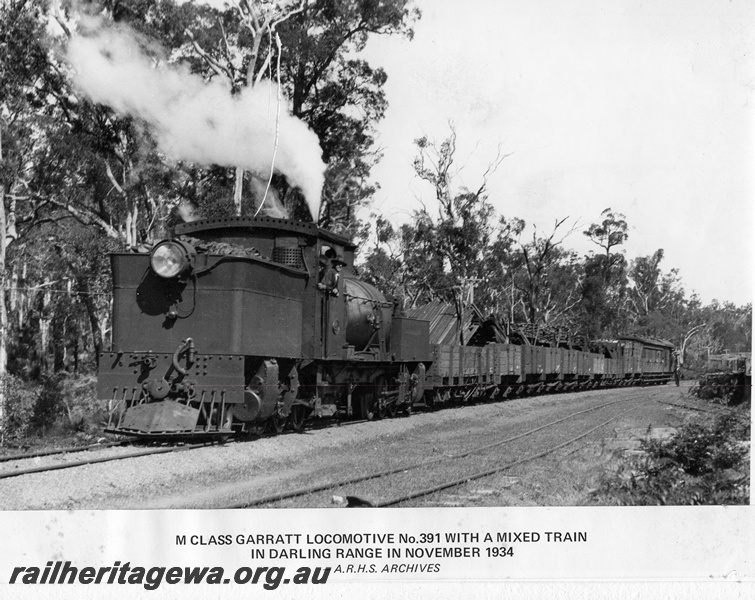 P14891
M class 391 Garratt articulated steam locomotive, on a mixed goods train, extended bunker, running bunker first, bunker and side view, Darling Range.
