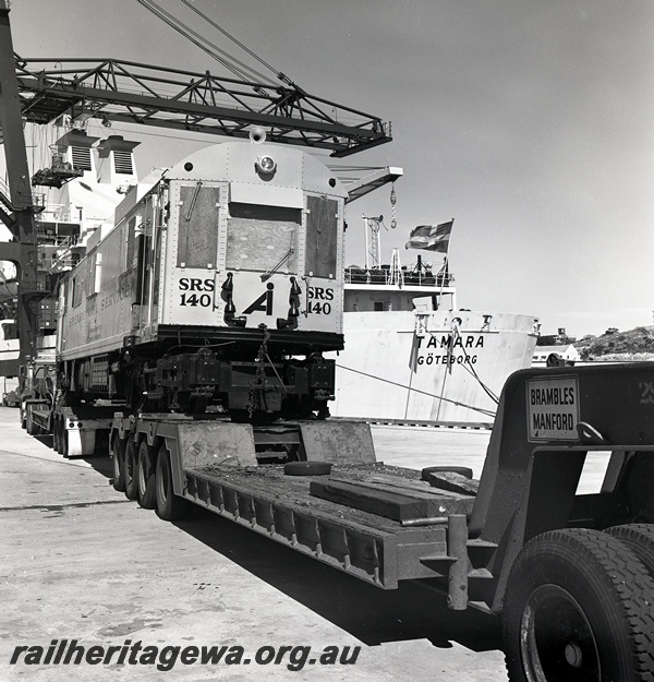 P15052
Sperry Rail Service railcar 140, on road transport trailer, end view, part of Fremantle Port Authority crane arm, ship 