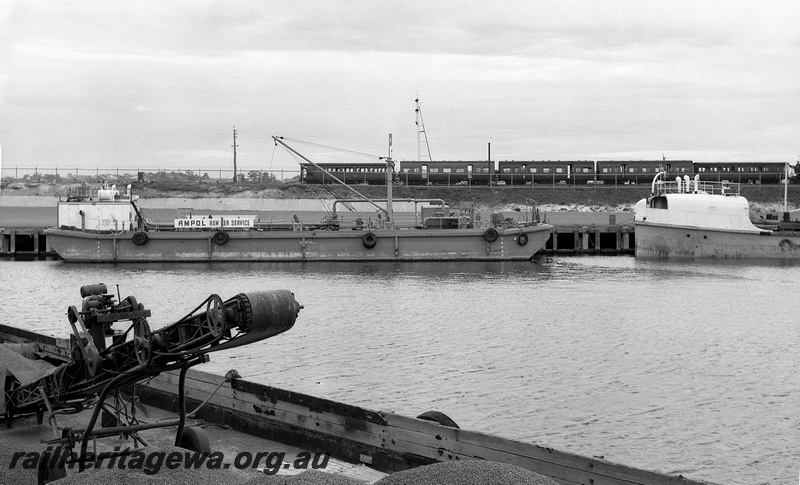 P15057
Rake of passenger carriages comprising 3 AJ class cars bookended by 2 AD class cars, side view, bracket signal, Ampol Bunker Service vessel and two others docked, Berth 10A, North Quay, Fremantle Port, c1959
