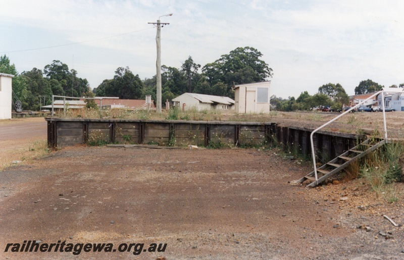 P15195
5 of 7 images of the railway precinct at Manjimup, PP line. Abandoned loading platform with the weighbridge building on the higher level in the background

