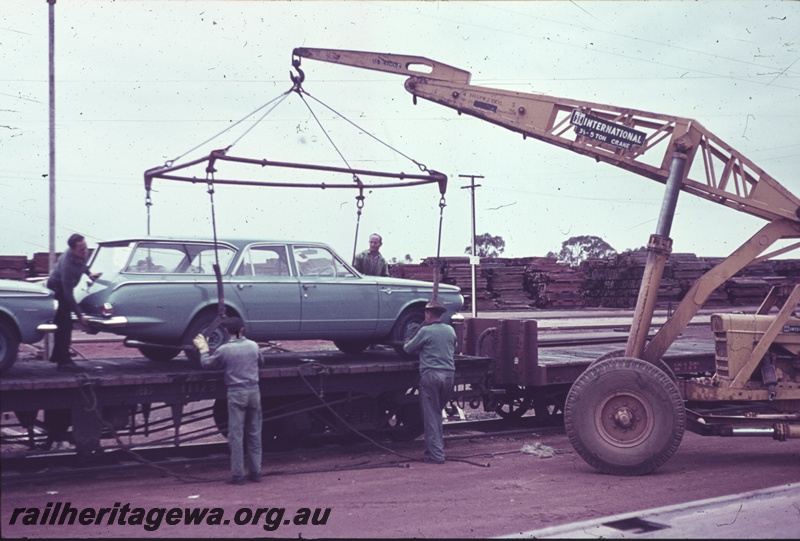 P15209
Transhipping a motor vehicle onto a WAGR bogie flat wagon using a mobile crane, Parkeston
