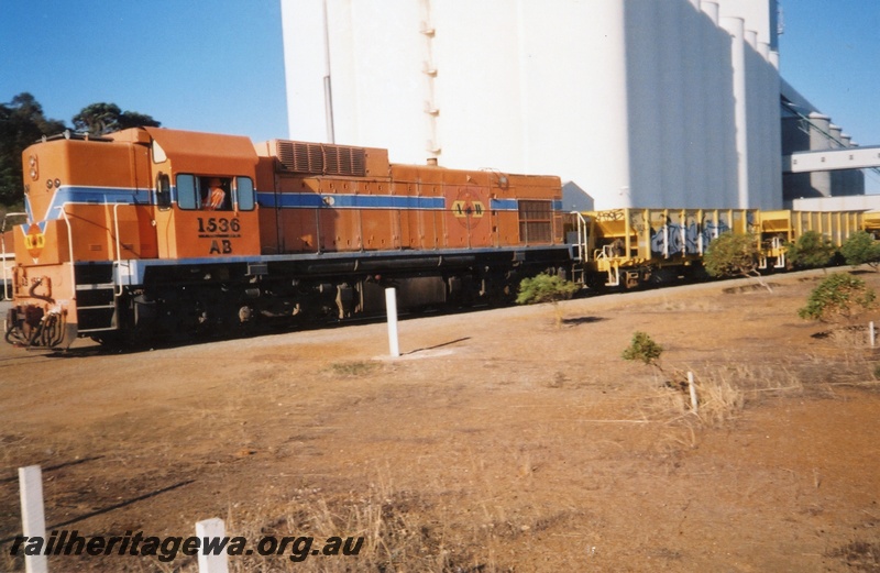 P15321
AB class 1536, in Westrail orange and blue livery but with the Australia Western Railroad initials and logo, on ballast train, CBH wheat silos and conveyor in background, Albany, GSR line, front and side view
