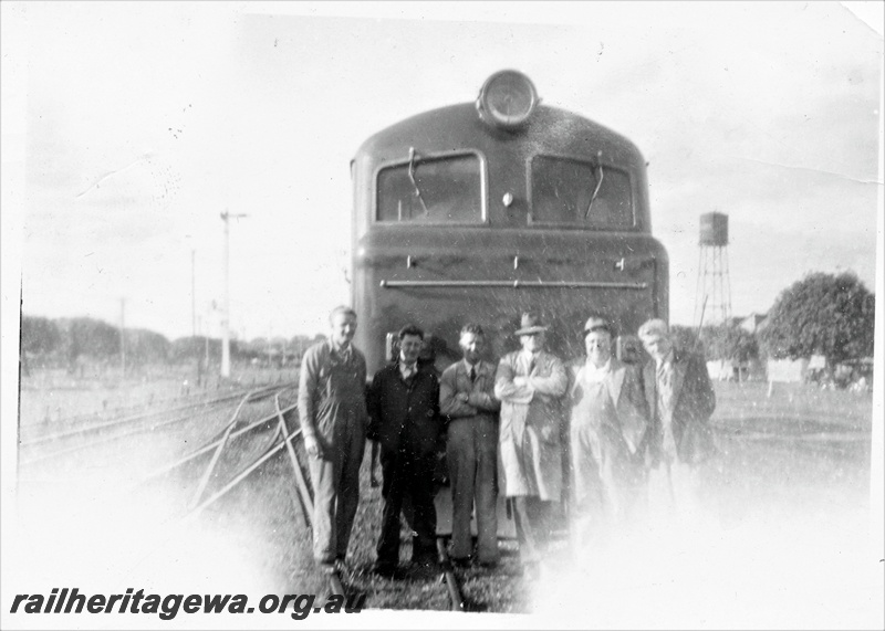 P15635
X class loco in original green livery, group of men standing in front of the loco, J. Parr possibly on the far right, water tower in the background, possibly at Maylands
