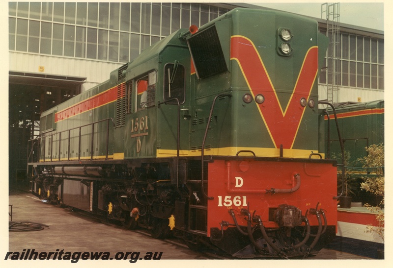 P15878
D class 1561, in green with red and yellow stripe livery, standing outside shed, side and front view
