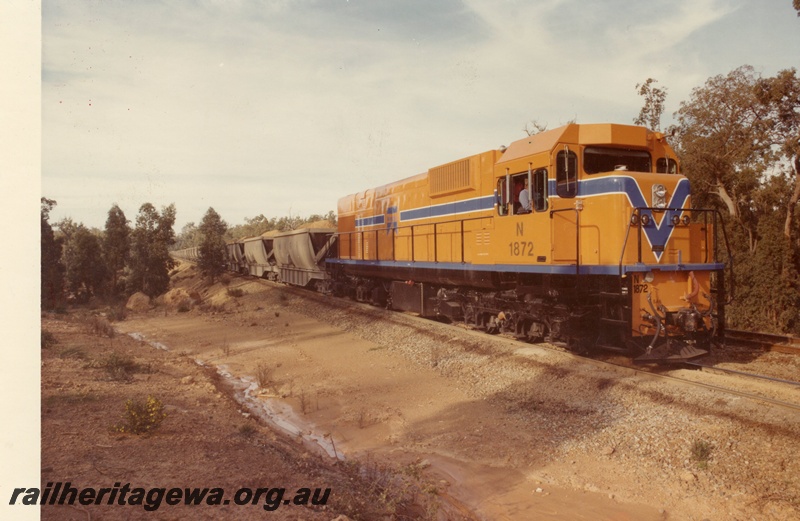 P15898
N class 1872, in Westrail orange with blue and white stripe, on bauxite train, trackside drain, rural setting, side and front view
