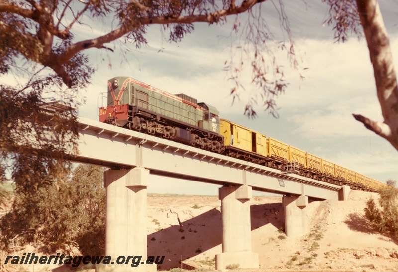 P15903
AA class 1517, in green with red and yellow stripe livery, hauling mineral sands train, crossing concrete and steel bridge, front and side view
