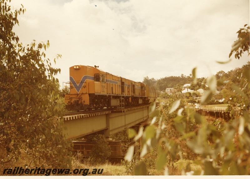 P15909
RA class 1909, in Westrail orange with blue and white strip, with another diesel loco, double heading wood chip train, crossing concrete and steel bridge, near Bridgetown, PP line

