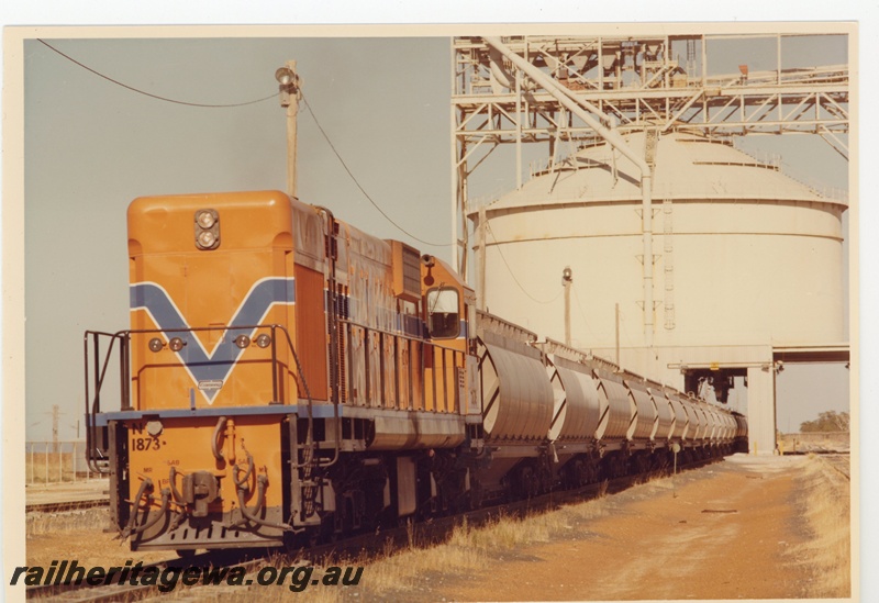 P15964
N class 1873, in Westrail orange with blue and white stripe, on alumina train of XF class wagons being loaded from above, loader, front and side view
