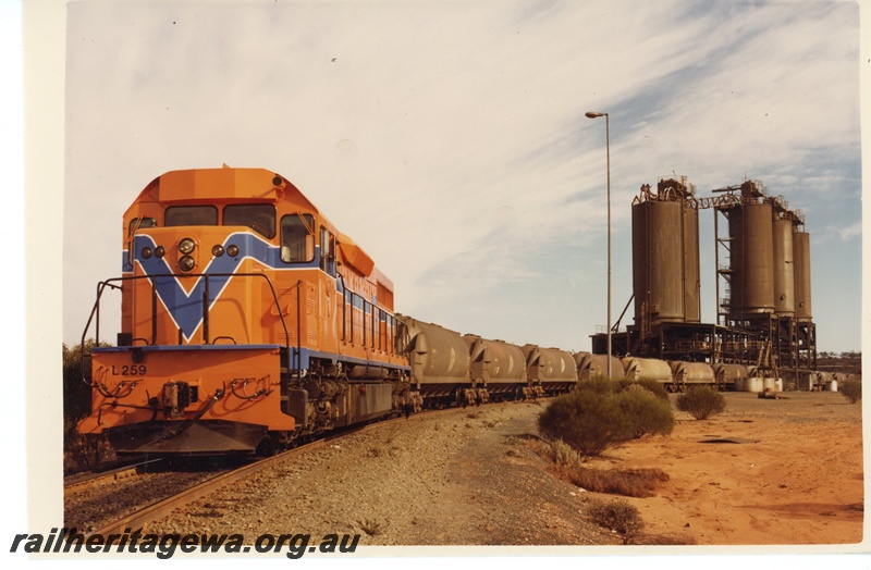 P15973
L class 259, in Westrail orange with blue and white stripe, on train comprising WN class hoppers, loading, nickel loader, front and side view
