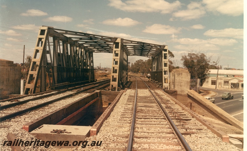 P16010
Mount Lawley Subway, steel girder bridge, in preparation for the laying of standard gauge tracks over bridge, cars emerging from subway, shop advertising 